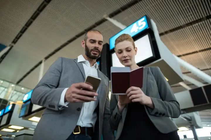 Travelers checking flight details at the gate